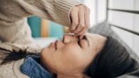 woman laying down suffering from migraine